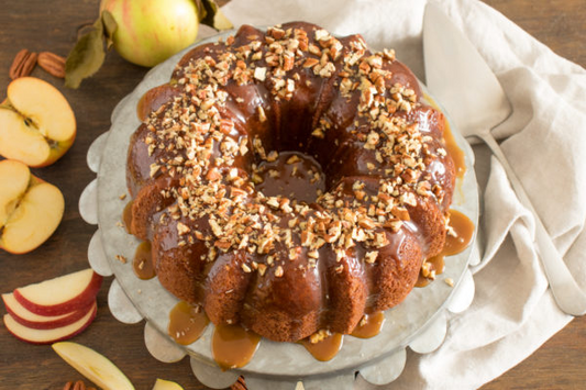Apple Pecan Pound cake in bundt style with pecans and caramels dripping over the top