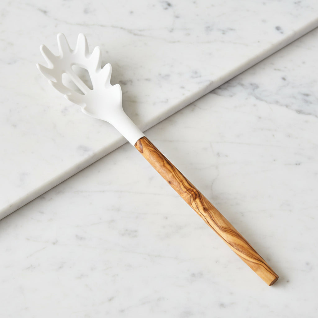 A spaghetti server with an olive wood handle and a white silicone head with pasta-shaped openings.