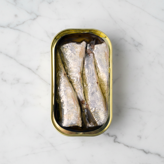 Canned fish in a gold can on a white background