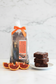 A Blood Orange Brownie Kit gift set in a clear cellophane bag tied with an orange ribbon, containing chocolate brownies, blood orange oil, and gold foil accents, with a product label visible.