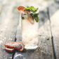 Refreshing drink with ice and garnishes on a wooden surface